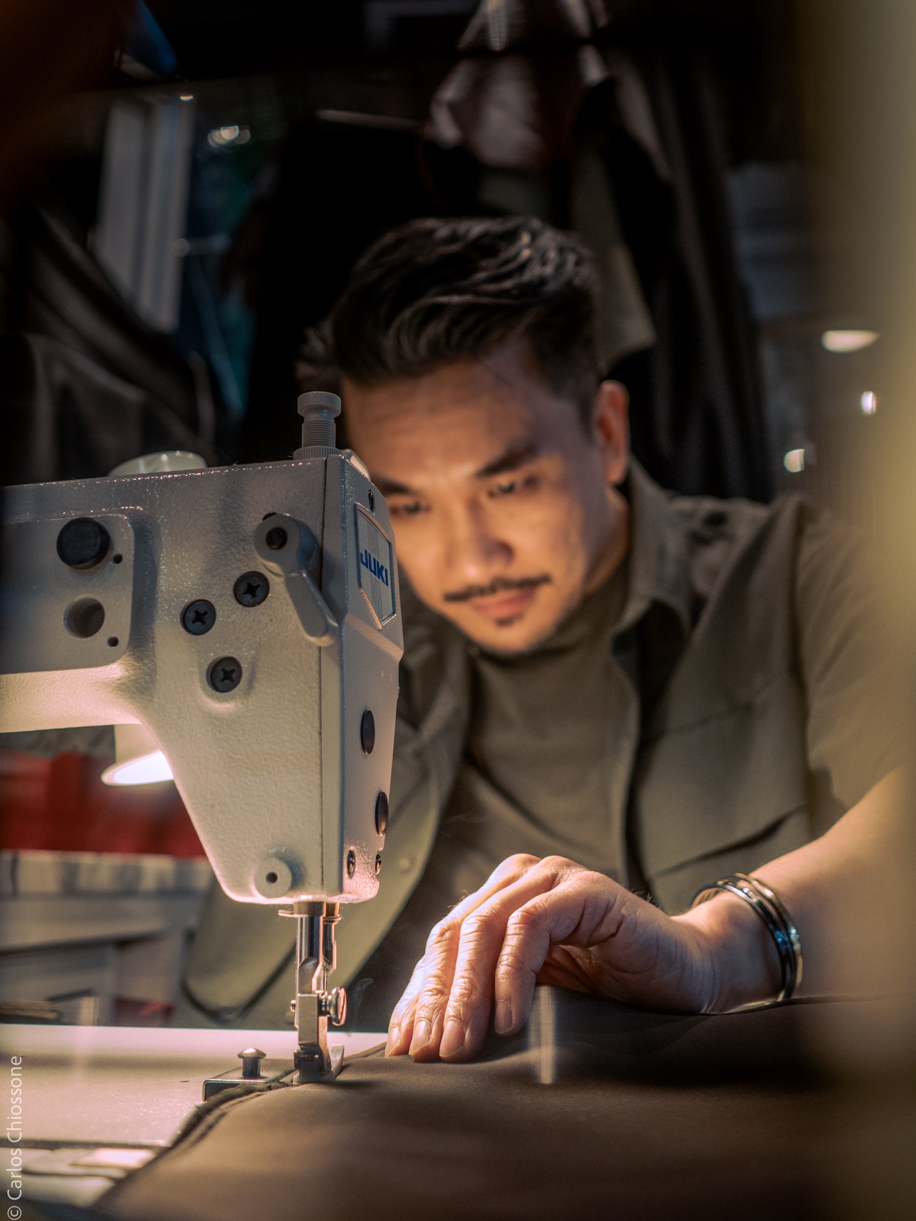 David Lee founder of Smith+Parka working on a sewing machine in a workshop setting